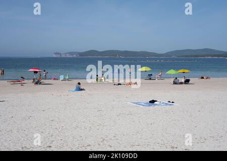 Vue sur la plage de Spiaggia del Lido di Alghero près de la vieille ville d'Alghero, Sardaigne, Italie avec les falaises de Capo Caccia au loin Banque D'Images