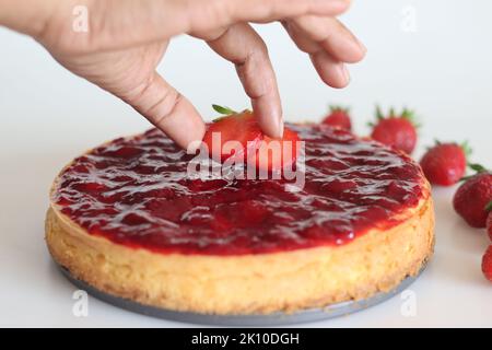 Décoration du gâteau au fromage fraise avec fraise fraîche sur le dessus. Gâteau au fromage soyeux et crémeux avec garnitures de fraises fraîches maison. Banque D'Images