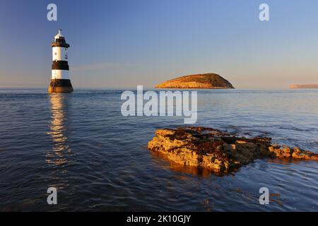 Penmon Lighthouse et Puffin Island lors d'une soirée d'été calme. Anglesey, pays de Galles du Nord, Royaume-Uni. Banque D'Images