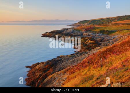 Vue de point Lynas en direction de Snowdonia au premier feu. Anglesey, pays de Galles du Nord, Royaume-Uni. Banque D'Images