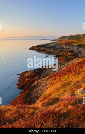 Vue de point Lynas en direction de Snowdonia au premier feu. Anglesey, pays de Galles du Nord, Royaume-Uni. Banque D'Images