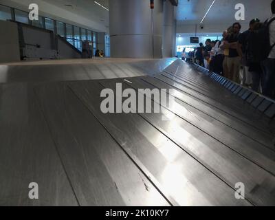 Delhi , Inde - 14th mai 2019 : vue rapprochée de la ceinture à bagages automatisée de l'aéroport en mouvement, les passagers attendent leurs bagages à côté de la ceinture vide Banque D'Images