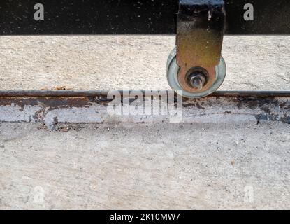 Les roues métalliques de la porte coulissante sur le rail de la maison rurale, vue de face avec l'espace copie. Banque D'Images