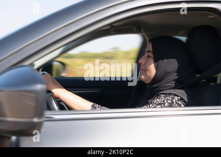 Gros plan sur une femme musulmane volant d'une voiture Banque D'Images