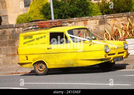 Une réplique de Trotters Yellow reliant Robin de la sitcom TV 'Only Fools & Horses' vu comme une voiture de mariage à Swillington, Leeds, Royaume-Uni Banque D'Images