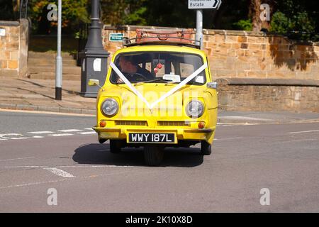 Une réplique de Trotters Yellow reliant Robin de la sitcom TV 'Only Fools & Horses' vu comme une voiture de mariage à Swillington, Leeds, Royaume-Uni Banque D'Images