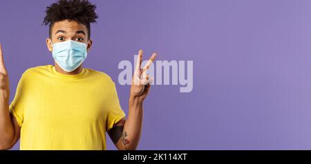 Médecine, covid19, coronavirus et concept humain. Un homme hispanique aux cheveux afro, portez un masque médical et montrez des signes de paix en restant Banque D'Images