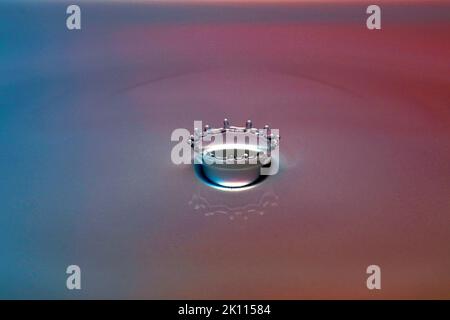 Une goutte tombe dans l'eau et crée de grandes formes Banque D'Images