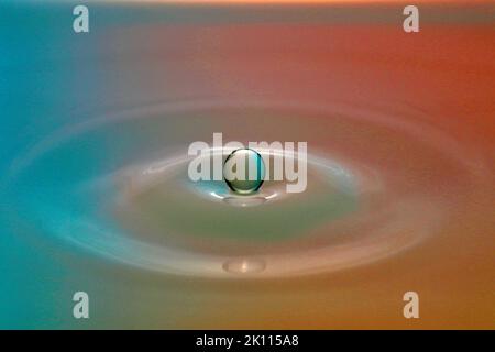 Une goutte tombe dans l'eau et crée de grandes formes Banque D'Images