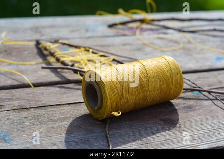 Bobine de fil ciré sur fond en bois Banque D'Images