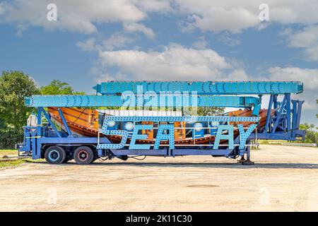 Le tour d'amusement Sea Ray a emballé sur une semi-remorque assis dans un parking vide de terre Banque D'Images