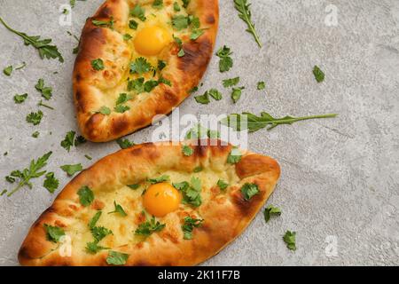 Délicieux khachapuri d'Ajarian avec des verts sur fond clair Banque D'Images