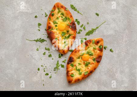 Délicieux khachapuri d'Ajarian avec des verts sur fond clair Banque D'Images