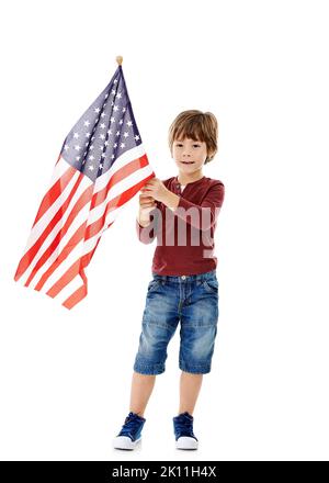 Je vole parce que je suis pour lui. Photo studio d'un petit garçon mignon tenant le drapeau américain sur un fond blanc. Banque D'Images