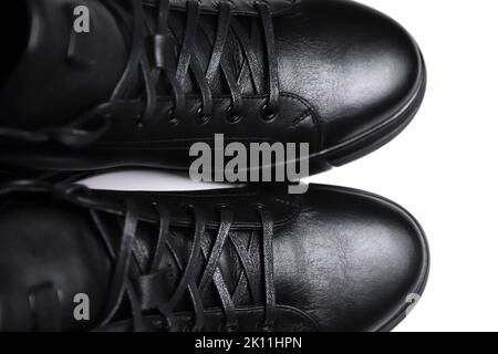 Chaussures homme en cuir noir effet de flou artistique, fond blanc. Chaussure montante en cuir pour hommes, isolée sur fond blanc, fermée. Bottes d'hiver. Gros plan. Vue de dessus. Banque D'Images