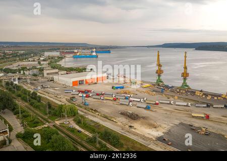 Camions et grues de port prêts à être chargés à partir de navires de cargaison. Vue horizontale Banque D'Images