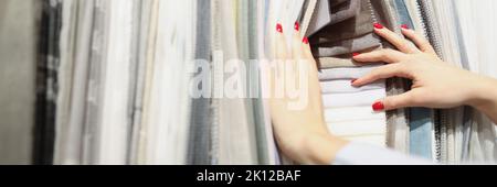 Femme choisit le tissu de la nouvelle collection dans le salon Banque D'Images