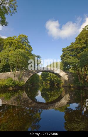 Le pont Ivelet datant du 16th siècle et son reflet dans la vallée de la rivière Swale, Swaledale, parc national de Yorkshire Dales, Angleterre Banque D'Images