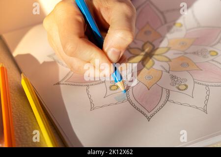 Page de coloriage antistress pour femme. Femme peinture main mandala. Femme peinture mandalas pour combattre le stress. Détente passe-temps bien-être mental et art thérapie. Femme peint le dessin, processus méditatif de colorier les pages. Expression de soi par l'art Banque D'Images