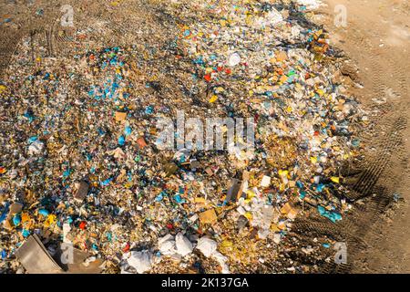 Pollution de l'environnement causée par d'énormes piles de déchets plastiques provenant d'usines de production industrielle. Décharge à ordures avec ordures sur la vue aérienne de jour ensoleillé Banque D'Images