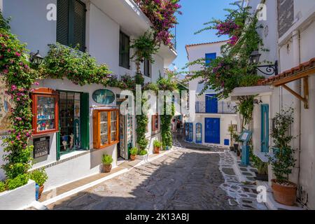 Vue sur les boutiques de la rue blanchie à la chaux dans la ville de Skiathos, l'île de Skiathos, les îles Sporades, les îles grecques, la Grèce, Europe Banque D'Images