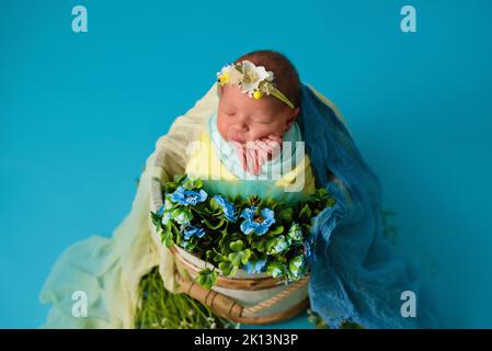 Nouveau-né ukrainien dans le studio patriotique bleu jaune couleurs pendant la guerre en Ukraine 2022. Un petit bébé, une fille dort sur un fond isolé Banque D'Images