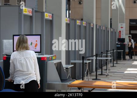 Le personnel de sécurité vérifie les sacs et les sacs à dos à la porte d'accès. Banque D'Images