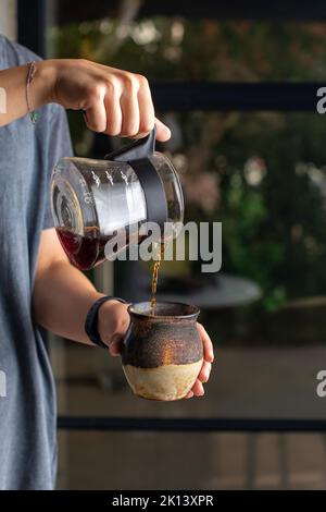 Versez un délicieux café dans une belle tasse Banque D'Images