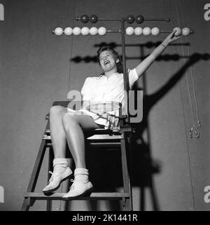 Tennis en 1940s. Une jeune femme est assise dans la chaise du jongleur de tennis. Les boules en bois de chaque côté sont pour marquer visuellement les jeux gagnés et les ensembles pour chaque joueur Suède 1942 Kristoffersson réf. M92-5 Banque D'Images