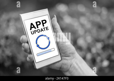 Main féminine tenant un smartphone avec concept de mise à jour d'application Banque D'Images