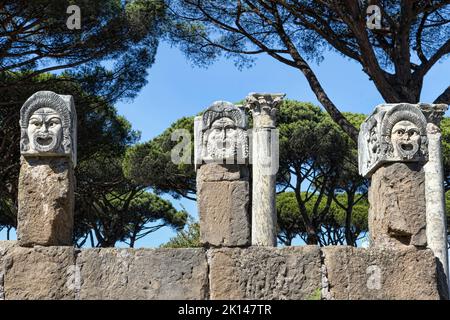 Œuvres d'art romaines anciennes trois masques ornementaux sculptés qui faisaient partie à l'origine de la décoration du théâtre romain d'Ostia Antica, R Banque D'Images