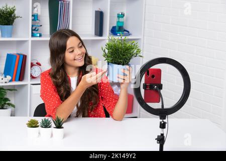 Jeune fille parlant devant l'appareil photo pour vlog. Adolescent travaillant comme blogueur, enregistrement de blog vidéo. Visage de fille heureux, émotions positives et souriantes. Banque D'Images