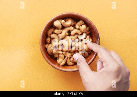 cueillez à la main la noix de cajou dans un bol Banque D'Images