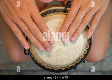 Atelier bongo africain. Personne jouant un djembe avec ses mains. Vue aérienne. Mise au point sélective Banque D'Images