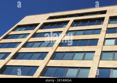 Vue détaillée d'une façade de bâtiment de bureau avec fenêtres visibles sous un angle bas. Banque D'Images