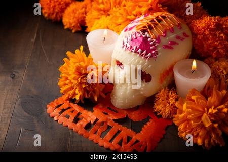 Crânes de sucre avec bougie, fleurs de Cempasuchil ou Marigold et Papel Picado.Décoration traditionnellement utilisée dans les autels pour la célébration du jour de Banque D'Images
