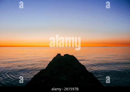 Magnifique coucher de soleil orange sur la mer à Trefor Beach, pays de Galles en été Banque D'Images