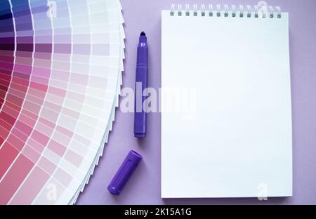 Échantillons de peinture, nuance multi-couleurs pour la conception. Arrière-plan lilas, bloc-notes, marqueur violet. Copier l'espace. Banque D'Images