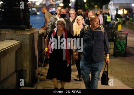 Une dame porte un drapeau de l'Union Jack en tant que foulard face au Parlement britannique pour voir le cercueil de la reine Elizabeth II comme il se trouve dans l'État à l'intérieur de Westminster Hall, au Palais de Westminster. Les membres du public peuvent rendre hommage à sa Majesté la reine Elizabeth II pendant 23 heures par jour à partir de 14 septembre 2022. Une longue file d'attente devrait s'étendre sur 10 kilomètres à travers Londres et un million de personnes devraient se joindre à l'État menteur de la reine Elizabeth II au Palais de Westminster dans les prochains jours jusqu'aux funérailles à 06:30 lundi, 19 septembre 2022. Banque D'Images