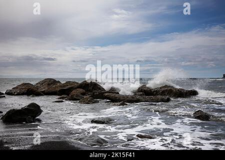 WA22018-00...WASHINGTON - rupture de vague sur des rochers près de Hole-in-the-Wall sur la plage du Rialto dans le parc national olympique. Banque D'Images