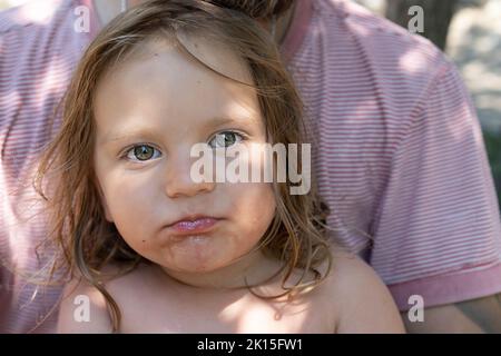 Portrait d'un bébé mignon. Le gamin mange une pastèque et regarde la caméra . Style de vie. Franc. Le concept de vacances familiales actives. Vue avant. Gros plan. Banque D'Images