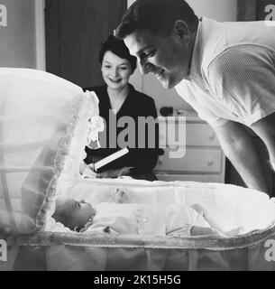 Les parents souriants admirent leur nouveau-né.1958 Banque D'Images