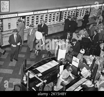 Horn & Hardart Automat Cafeteria on Avenue of the Americas at West 45th St., New York City, 1959.Horn & Hardart a ouvert le premier service de restauration automatique à New York à Times Square le 2 juillet 1912.Ils ont pris le concept d'une version allemande réussie.Leur slogan était « moins de travail pour mère ».Vers le milieu du 20th siècle, il y avait plus de 50 restaurants Horn & Hardart à New York, servant 350 000 clients par jour.En 1960s, les franchises de fast-food ont gagné en popularité et les automates ont commencé à fermer. Banque D'Images