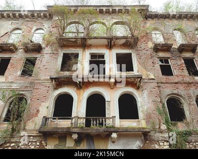 Vieux bâtiment abandonné en ruine avec fenêtres en arches. Vue de dessous. Banque D'Images