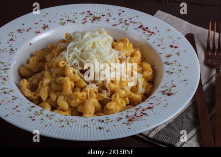 Mac et fromage, pâtes de macaroni de style américain avec sauce cheesy sur table rustique sombre, vue sur le dessus Banque D'Images