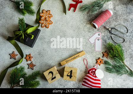 Cadre de Noël avec boîte cadeau et décoration de fête sur fond de béton Banque D'Images