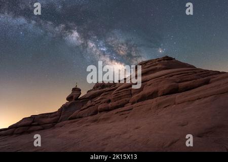 Faible angle de voyageur debout Balanced Rock formation situé contre la voie lactée lumineuse au ciel nocturne dans l'Utah, États-Unis Banque D'Images