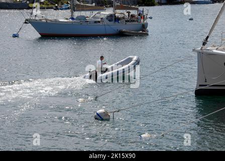 Homme dans un petit bateau gonflable avec moteur hors-bord sur Simpson Bay Lagoon, Saint Martin, Caraïbes Banque D'Images