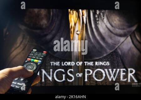 Belgrade, Serbie - 12 septembre 2022: Le Seigneur des anneaux: Les anneaux de puissance série TV à la télévision avec télécommande en main. Mise au point sur la télécommande suite Banque D'Images