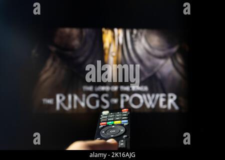 Belgrade, Serbie - 12 septembre 2022: Le Seigneur des anneaux: Les anneaux de puissance série TV à la télévision avec télécommande en main. Mise au point sur la télécommande suite Banque D'Images